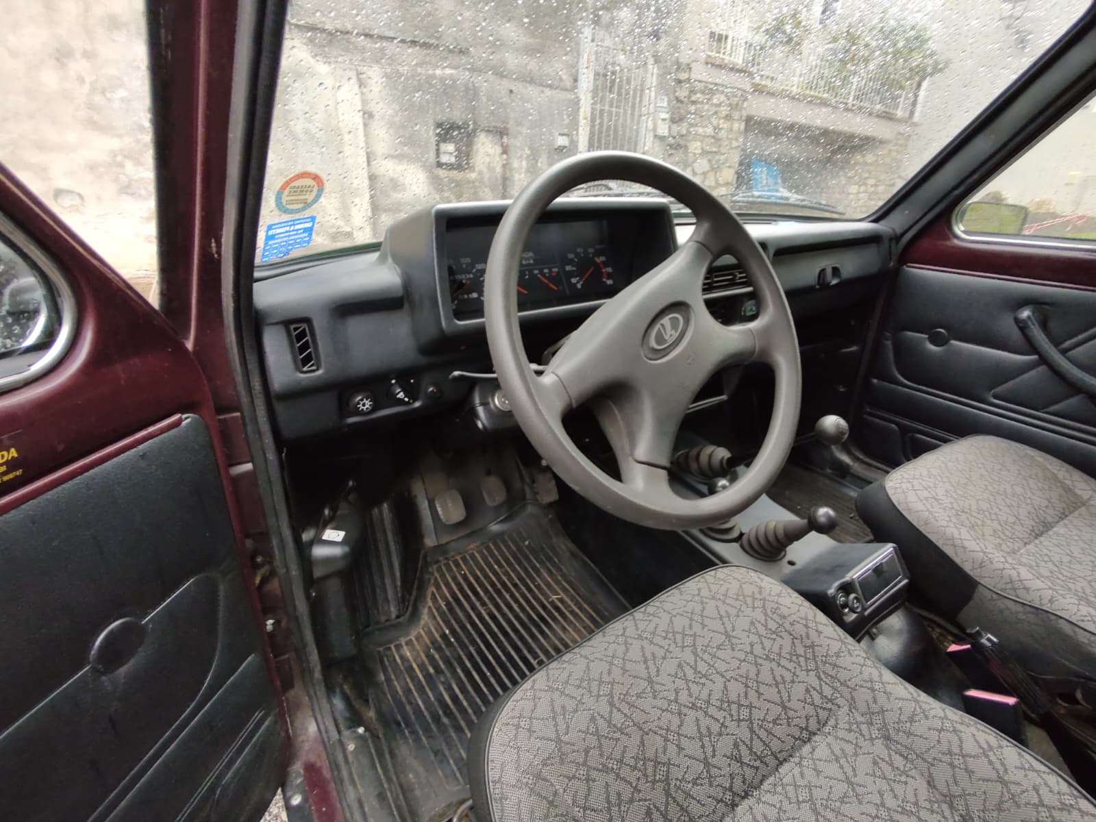 The simple mechanical dashboard and steering wheel inside the Lada Niva