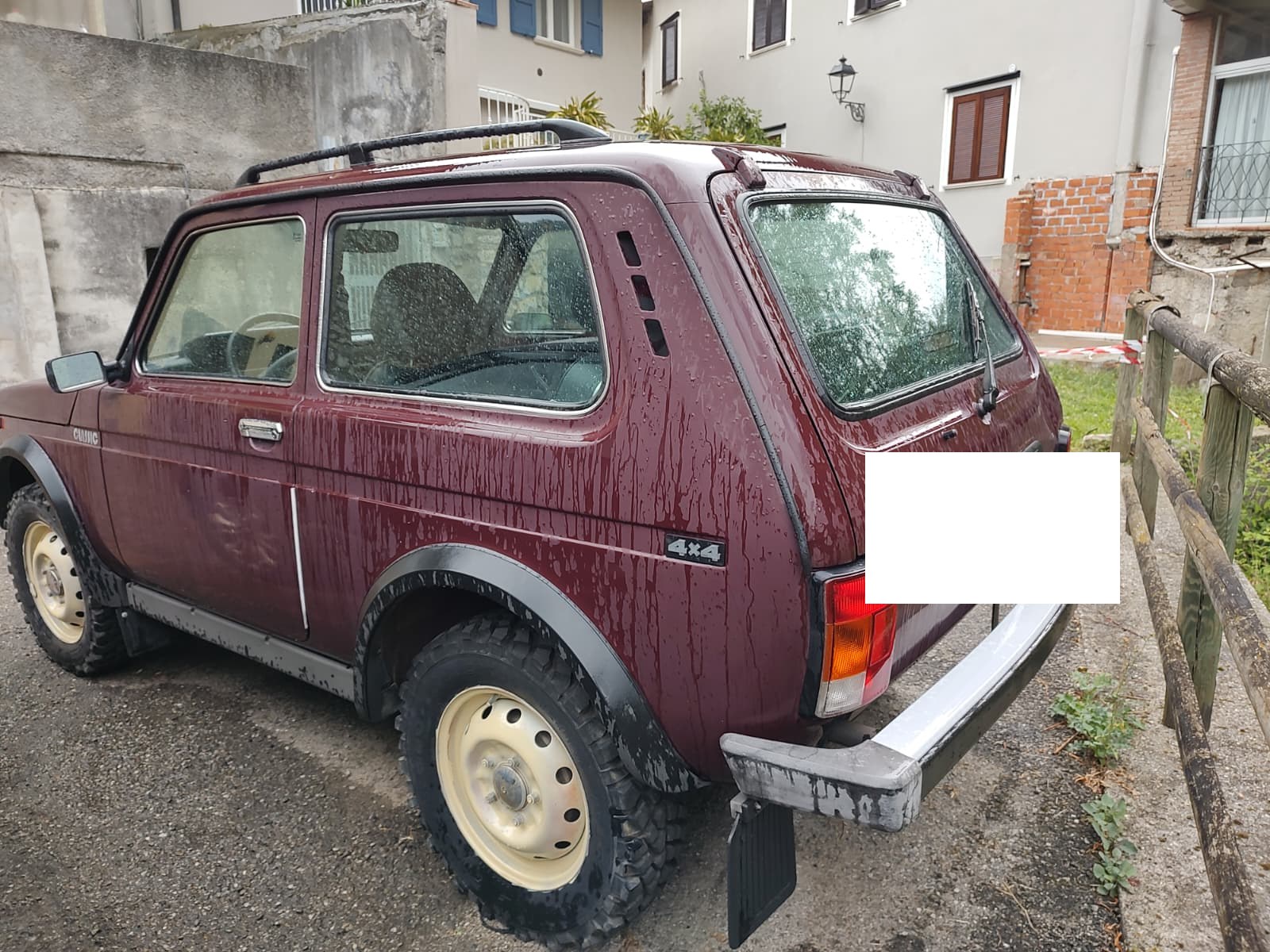 The Lada Niva parked outside, rear three-quarter view