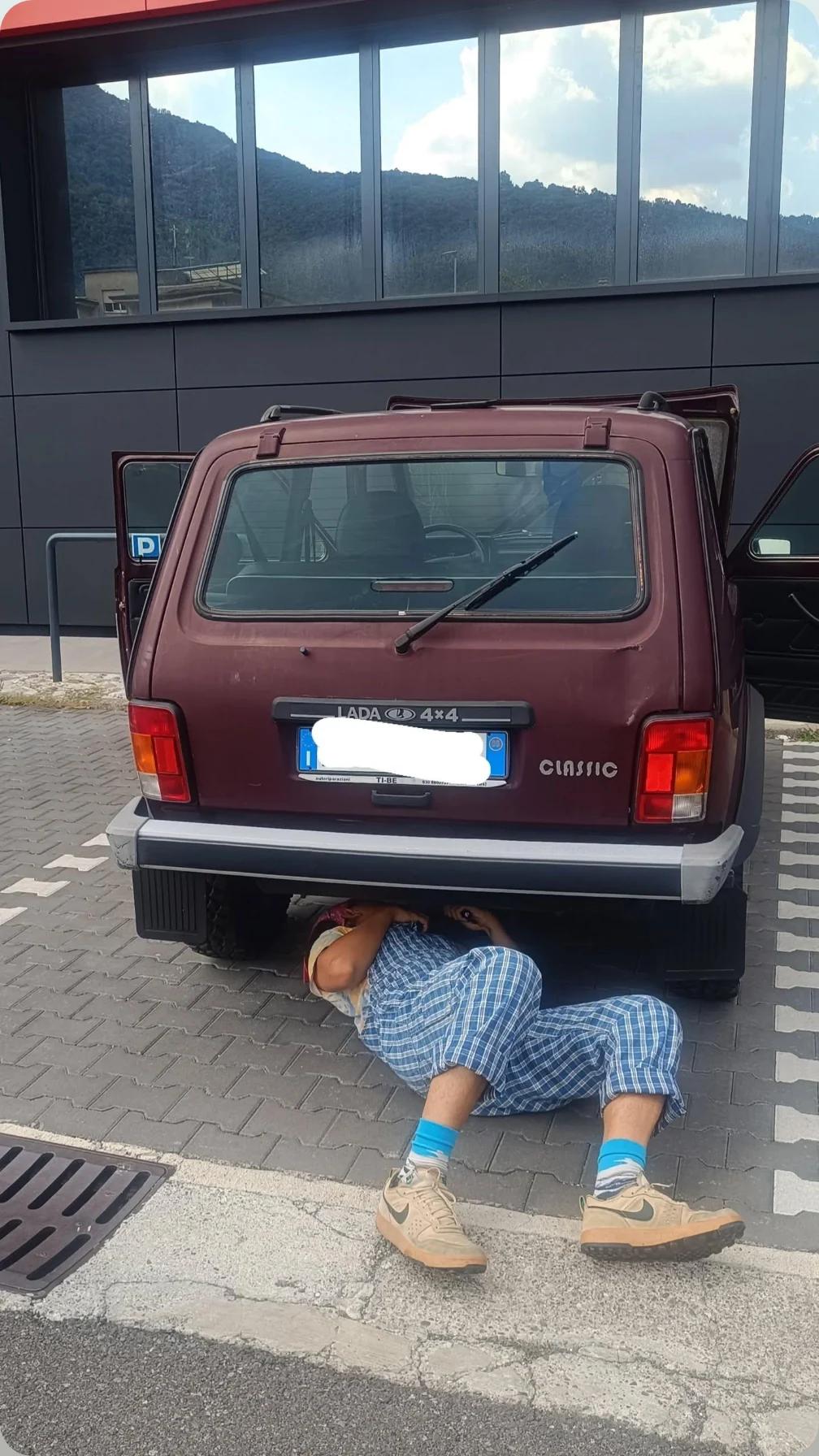 Filippo lying underneath the Lada Niva, repairing the underside